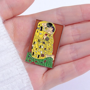 Macro shot of Klimt The Kiss enamel pin badge on white knitted fabric background
