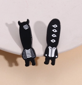Creative black and white enamel pins set featuring cartoon ghost characters on a display