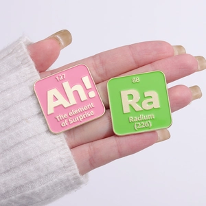 Set of colorful enamel pins featuring chemical elements Ah and Ra on white sweater cuff
