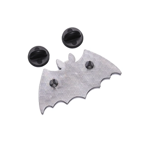 Detail of bat-shaped enamel pin back with honeycomb texture and black rubber clutches
