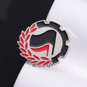 Antifa-style round metal badge with flags and gear design on a monochrome background