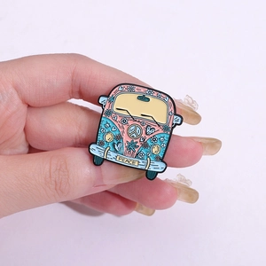 Colorful hippie bus enamel pin with floral patterns and Peace sign held in hand