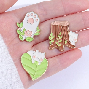 Three cute enamel cat pins featuring kitten in tree stump and sleeping on leaf charms