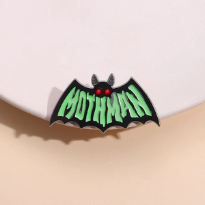 Glow-in-the-dark mothman enamel pin with red eyes and green lettering for Halloween decor