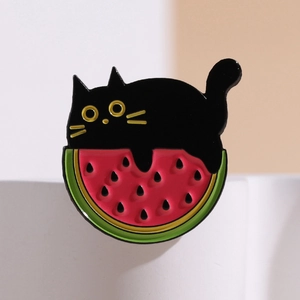 Cartoon black cat on watermelon enamel pin badge with vibrant colors and golden trim