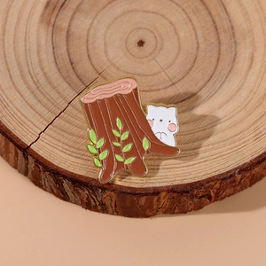 Detailed close-up of a white cat and tree stump enamel pin on a wooden base decor