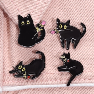 Lot de quatre broches chat noir en émail avec des roses sur fond de tissu rose