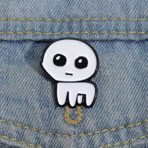 Close-up of a white TBH Creature enamel pin badge attached to blue denim fabric