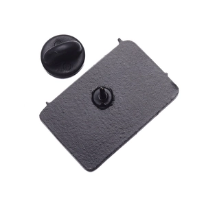 Detail of the back of a square metal pin badge with a black rubber clutch closure