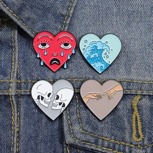 Group of four artistic heart-shaped enamel pins styled on a blue denim jacket fabric