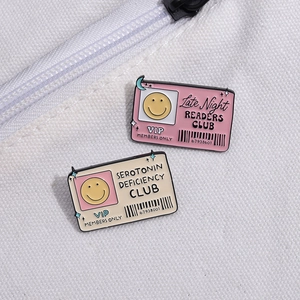 Badges créatifs en émail rose et beige épinglés sur un sac en toile blanche