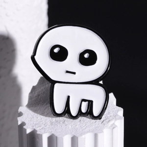 Minimalist TBH Creature enamel pin on a decorative white column with high contrast lighting