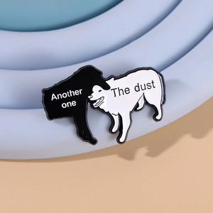 Detailed view of enamel pins featuring black and white dogs with creative puns