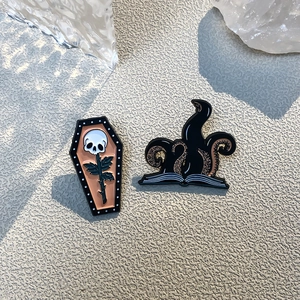 Gothic enamel pin set with skull coffin and octopus tentacles on beige background