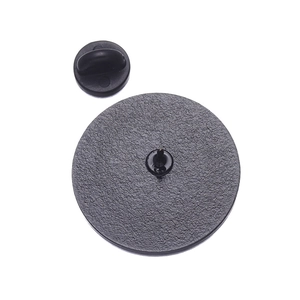 Detail of the round alloy badge back with metal pin and black rubber butterfly clutch