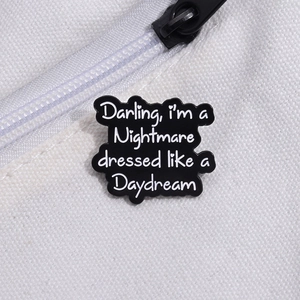 Détail du pin's émaillé sur sac en toile avec texte Darling I'm a Nightmare Daydream