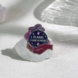 Gothic Magic Academy enamel pin with Make Your Magic slogan on crystal ball and hand
