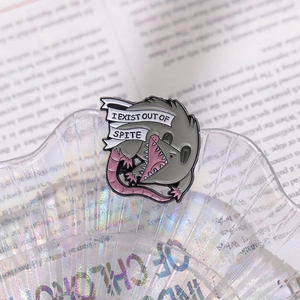 Funny cartoon opossum enamel pin badge with 'I EXIST OUT OF SPITE' text on shell tray