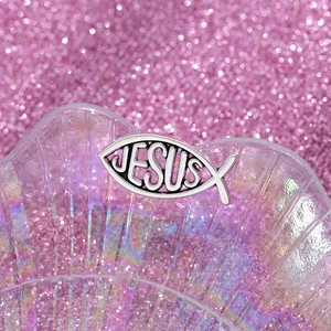 Detailed close-up of a silver alloy Ichthys fish brooch with Jesus hollow engraving