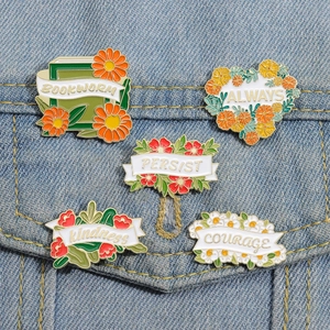 Detailed set of 5 floral enamel pins featuring motivational quotes on denim background
