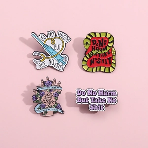 Enamel medical brooch set with snake and syringe design plus Do No Harm slogan