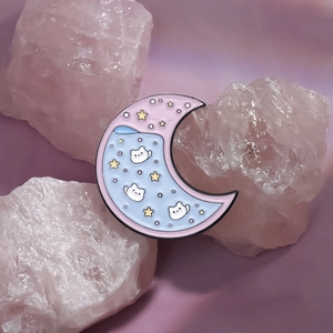 Pink moon enamel brooch with cute cats and stars displayed on pink crystal stones