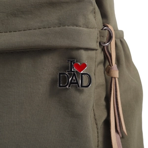 Dettaglio della spilla in metallo I Love DAD appuntata su tessuto di nylon verde oliva
