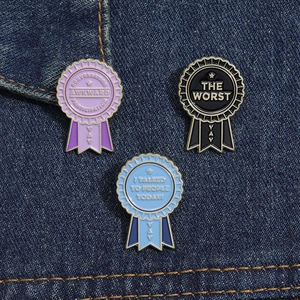 Detailed view of three colorful enamel award badges with motivational English quotes