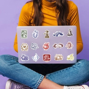 Detail of vintage waterproof stickers applied on a purple laptop in a lifestyle setting