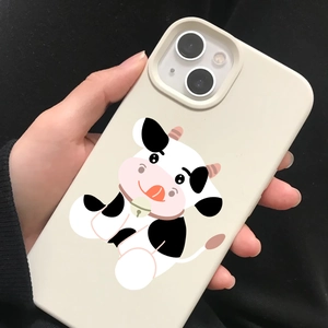 Close-up of creamy white iPhone case featuring a cute cartoon cow with a pink bell
