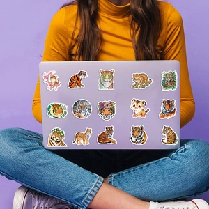 Detailed view of multiple tiger graffiti stickers applied on a laptop shell
