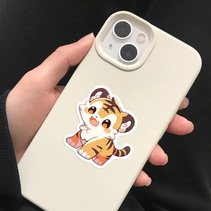 Hand holding creamy beige iPhone case with a cute cartoon tiger print on silicone material