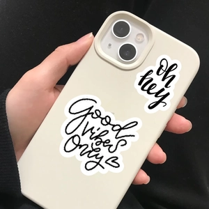 Dettaglio della custodia per telefono bianco crema con testo 'Good Vibes Only' nero