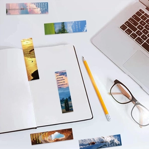 Close-up of landscape bookmarks with English quotes on a white notebook and desk