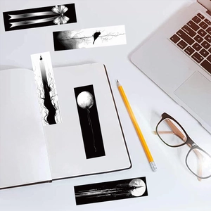 Artistic black and white bookmarks featuring minimalist ink sketches on an office desk