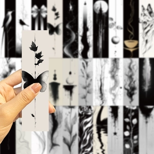 Detail of black ink bookmark featuring artistic butterfly and maple leaf pattern