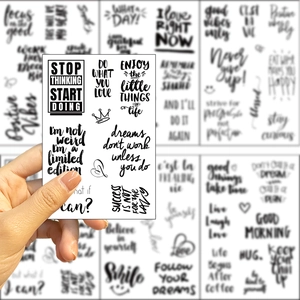 Vista macro di adesivi neri con frasi motivazionali e icone a cuore per decorazioni DIY