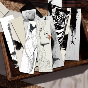 Artistic black and white ink bookmarks with scenery and floral designs in a wooden tray