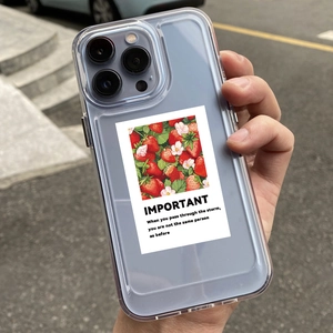 Close-up of a clear phone case with a waterproof strawberry sticker and English quote