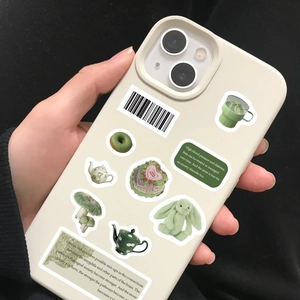 Close-up of cream iPhone case with green matcha themed aesthetic stickers and quotes