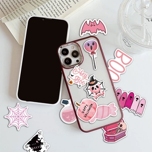 Autocollants d'Halloween roses décorant une coque de téléphone sur un bureau stylé