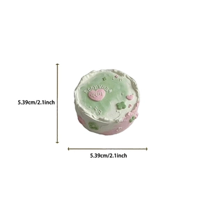Detail view of a mint green cream cake phone stand with Forever text, 2.1 inch diameter