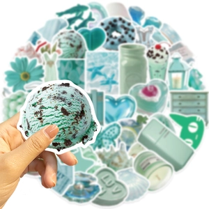 Macro shot of mint green aesthetic stickers for DIY decor on guitar and laptop
