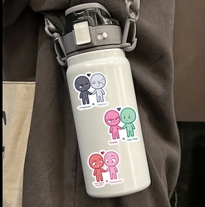 Weiße Sport-Trinkflasche mit Comic-Aufklebern und Tragegurt auf grauem Hoodie