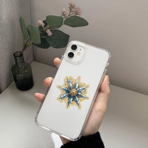Détail d'une coque iPhone transparente avec engrenages bleu et or et motif boussole