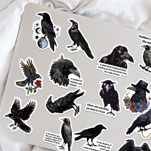 Detail of gothic raven waterproof stickers featuring moon and rose on a laptop surface