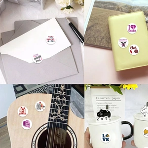 Roll of 500 cheerleading stickers shown on envelope, notebook, guitar and mug