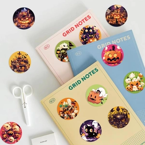 Halloween cartoon pumpkin stickers on a grid notebook with decorative office supplies
