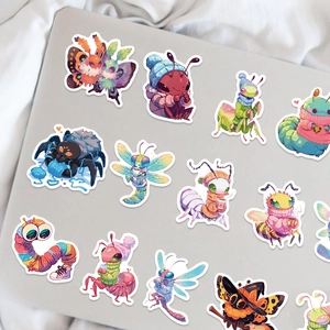 Dettaglio di adesivi di insetti a fumetti colorati applicati su un laptop grigio
