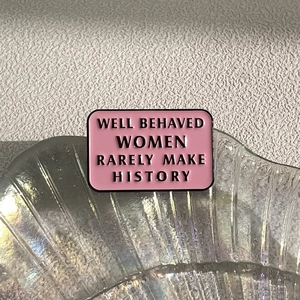 Pink enamel rectangle brooch with Well Behaved Women Rarely Make History text